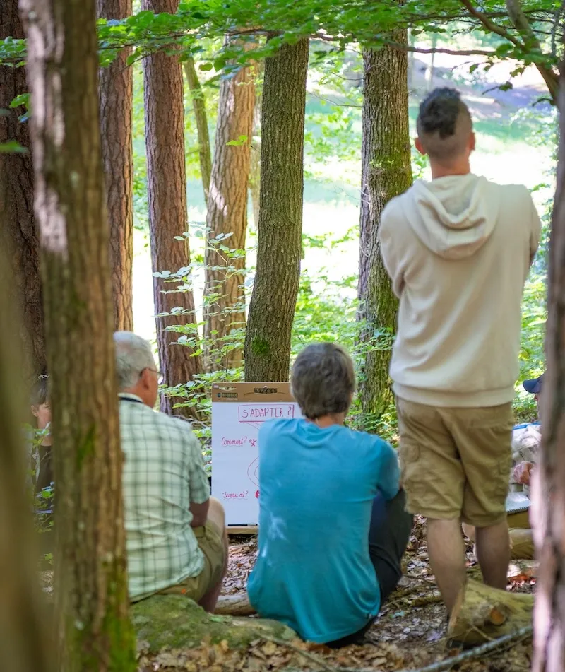 entrepreneurs entourés d'arbres avec l'inscription 's'adapter' sur un paperboard